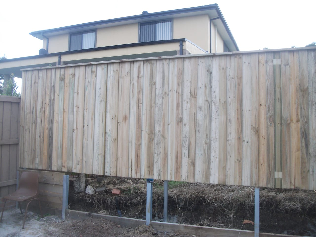 Newly installed treated pine timber paling fence running along a residential boundary beside a two-storey home in Northmead, Sydney